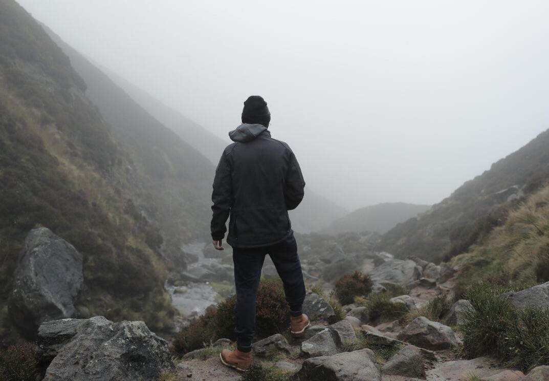 image of man on mountain facing away